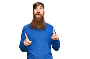 Genç İrlandalı kızıl elbiseli adam şaşkın ve şaşırmış bir şekilde yukarı baktı ve parmaklarıyla işaret etti ve kollarını kaldırdı.. 