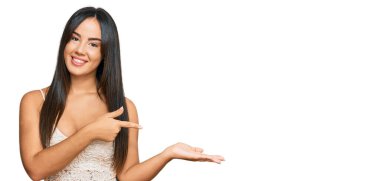 Gündelik giysiler giyen genç ve güzel İspanyol kız kameraya hayret ediyor ve gülümsüyor.. 