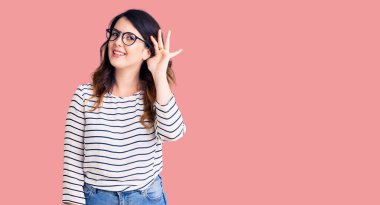 Güzel, genç, esmer bir kadın. Günlük kıyafetler ve gözlük takıyor. Kulaktan kulağa gülümsüyor. Sağırlık kavramı. 