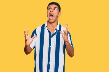 Genç Arap adam gündelik kıyafetler giyip deli gibi bağırıyor ve agresif bir ifade ve kollarla bağırıyor. hüsran kavramı. 