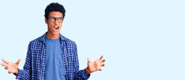 Sıradan kıyafetler giyen, gözlüklü, deli deli deli bağıran, bağıran saldırgan ifadeli ve kolları havada genç Afrikalı Amerikalı bir adam. hüsran kavramı. 