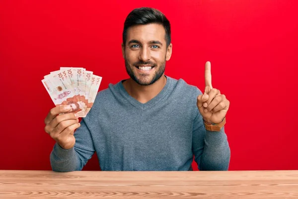 Hombre Hispano Guapo Sosteniendo Pesos Colombianos Sonriendo Con Una Idea — Foto de Stock