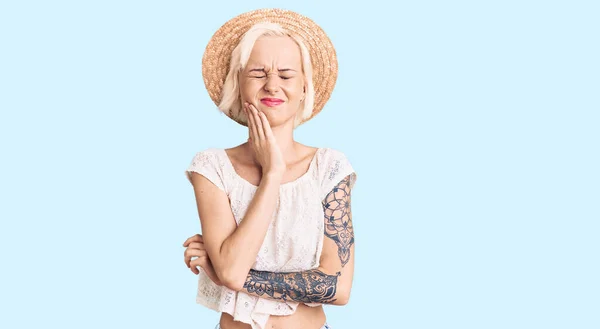 Νεαρή Ξανθιά Γυναίκα Τατουάζ Φοράει Καλοκαιρινό Καπέλο Αγγίζοντας Στόμα Χέρι — Φωτογραφία Αρχείου