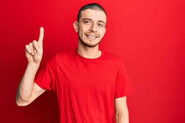 Jovem Hispânico Vestindo Casual Camiseta Vermelha Espreitando Choque Cobrindo Rosto — Fotografia de Stock