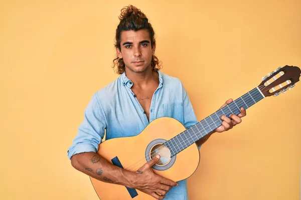 Giovane Ispanico Suonare Chitarra Classica Rilassato Con Espressione Seria Sul — Foto Stock