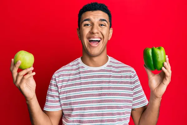 Young Arab Man Holding Green Apple Pepper Smiling Laughing Hard — Stock fotografie