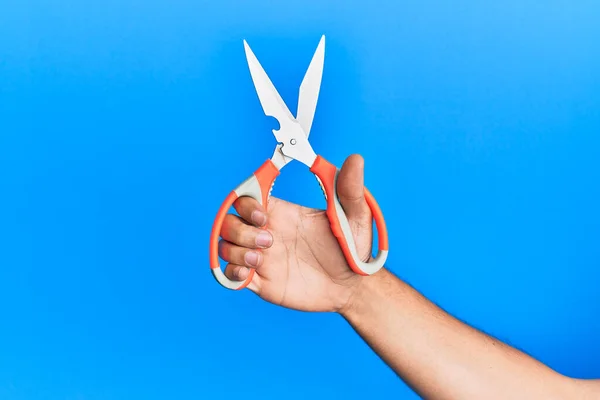 Mano Joven Hispano Usando Tijeras Sobre Fondo Azul Aislado —  Fotos de Stock