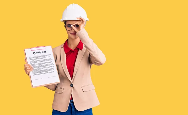 Jovem Bela Mulher Vestindo Arquiteto Hardhat Segurando Prancheta Com Contrato — Fotografia de Stock