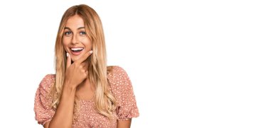 Yazlık bluz giyen güzel sarışın kadın kameraya bakarak kollarını kavuşturup gülümseyerek ve çenesini kaldırarak gülümsüyor. Olumlu düşünmek. 