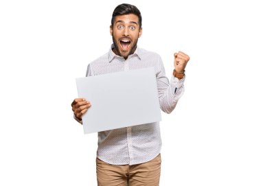 Yakışıklı İspanyol adam boş pankart tutuyor gururla bağırıyor, zaferi kutluyor ve kollarını kaldırarak heyecanlanıyor. 