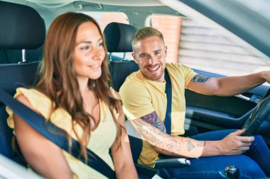 Gülümseyen mutlu araba kullanan genç çift.,