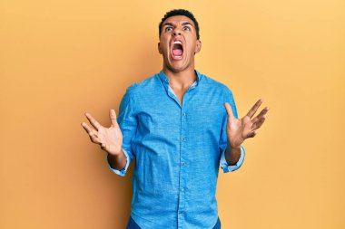 Genç Arap adam gündelik kıyafetler giyip deli gibi bağırıyor ve agresif bir ifade ve kollarla bağırıyor. hüsran kavramı. 