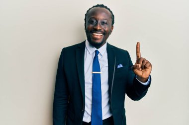 Yakışıklı, takım elbiseli ve kravatlı genç bir adam başarılı bir fikirle işaret ediyor. Heyecanlı ve mutlu. Bir numara.. 