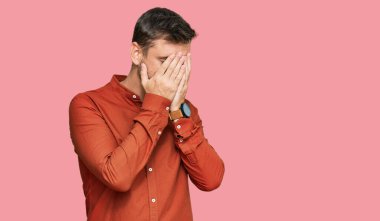 Yakışıklı, beyaz, sıradan kıyafetler giyen, suratını ellerle örten ve ağlayan bir adam. depresyon kavramı. 