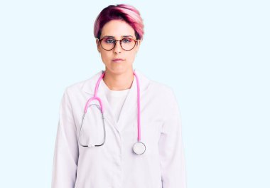 Pembe saçlı, doktor üniforması giyen, kuşkucu ve gergin, sorunlarından dolayı üzgün olan genç ve güzel bir kadın. negatif kişi. 