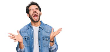 Gündelik kıyafetler giyen genç İspanyol adam başarı için deli ve çılgınlığı kutluyor kollarını kaldırmış ve gözlerini kapatmış heyecanla bağırıyor. Kazanan konsept 