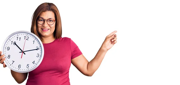 Middelaldrende Latinokvinne Med Stor Klokke Smilende Lykkelig Pekende Med Hånd – stockfoto