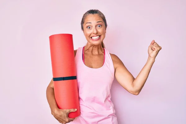 Mujer Hispana Mediana Edad Sosteniendo Esterilla Yoga Gritando Orgullosa Celebrando — Foto de Stock