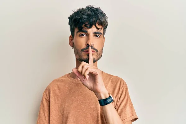 唇に指で静かにするように頼むカジュアルな服を着た若いヒスパニック系の男 沈黙と秘密の概念 — ストック写真
