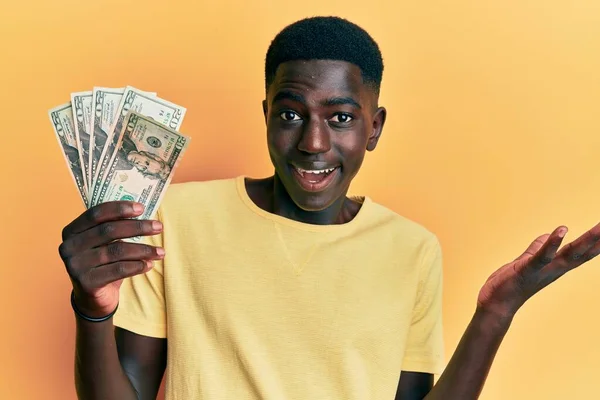 Νεαρός Αφροαμερικάνος Που Κρατάει Δολάρια Γιορτάζοντας Επίτευγμα Χαρούμενο Χαμόγελο Και — Φωτογραφία Αρχείου