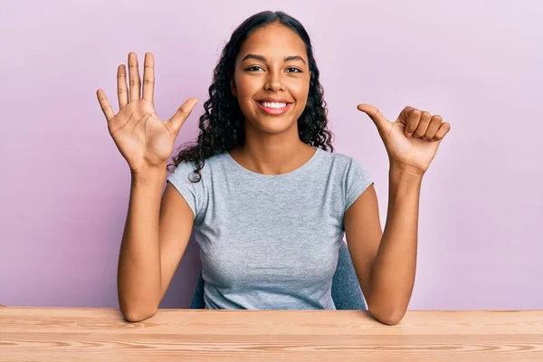 Ung Afrikansk Amerikansk Flicka Bär Casual Kläder Sitter Bordet Visar — Stockfoto