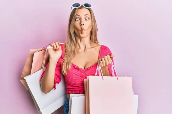 Beautiful Caucasian Woman Holding Shopping Bags Making Fish Face Mouth — Stock Photo, Image