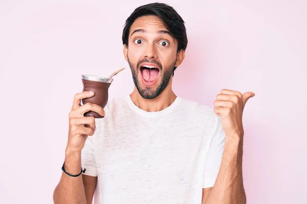 Hombre Hispano Guapo Bebiendo Mate Infusión Apuntando Pulgar Hacia Lado — Foto de Stock