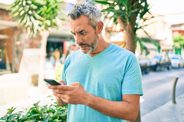 Šedovlasý Muž Středního Věku Používá Smartphone Ulici Města Vyděšený Ohromený — Stock fotografie