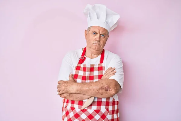 제빵사 앞치마를 백발의 노인은 의심과 긴장을 느끼며 얼굴을 붉히는 부정적 — 스톡 사진