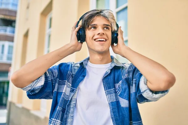 Joven Hombre Hispano Sonriendo Feliz Usando Teléfonos Inteligentes Auriculares Ciudad —  Fotos de Stock