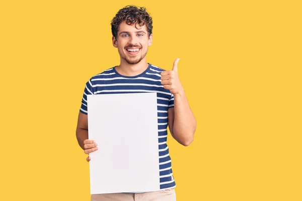 Jovem Homem Bonito Com Cabelo Encaracolado Segurando Banner Vazio Branco — Fotografia de Stock