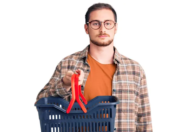 Joven Guapo Caucásico Hombre Sosteniendo Supermercado Cesta Pensamiento Actitud Expresión — Foto de Stock