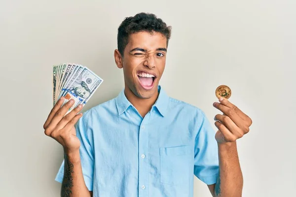 Joven Hombre Afroamericano Guapo Sosteniendo Bitcoin Moneda Virtual Dólares Guiño —  Fotos de Stock