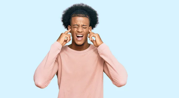 アフリカ系アメリカ人の男性は 耳を指で覆っているカジュアルな服を着ており 大きな音楽のノイズに悩まされていました 聴覚障害の概念 — ストック写真