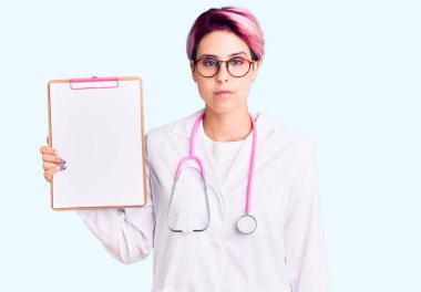 Pembe saçlı, doktor steteskobu takan genç ve güzel bir kadın. Elinde bir pano var. Tıbbi raporları var. 