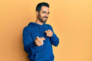 Sakallı, sıradan tişörtlü, stresli ve gergin görünen ağzı tırnak yiyen genç bir İspanyol. anksiyete. 