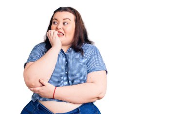 Genç ve cüsseli bir kadın. Günlük kıyafetler giyiyor. Stresli ve gergin görünüyor. anksiyete. 