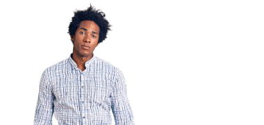 Afro saçlı yakışıklı Afro-Amerikan bir adam. Yüzünde ciddi bir ifade olan günlük kıyafetler giyiyor. Basit ve doğal bir şekilde kameraya bakıyorsun.. 