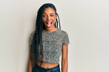 Sıradan kıyafetler giyen Afrikalı Amerikalı kadın kameraya seksi bir ifadeyle bakıyor, neşeli ve mutlu bir yüzle.. 