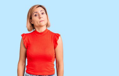 Sıradan kıyafetler giyen genç sarışın kadın yüzünde ciddi bir ifadeyle rahatlamış. Basit ve doğal bir şekilde kameraya bakıyorsun.. 