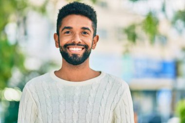 Genç Afrikalı Amerikalı adam parkta mutlu bir şekilde dikiliyor..