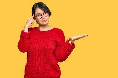 Kısa saçlı, sıradan süveter giyen, gözlüklü, açık avuç içiyle fotokopi çeken ve alnını işaret eden genç ve güzel İspanyol bir kadın. Bunu bir düşün.. 