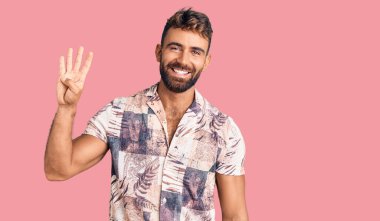 İspanyol asıllı genç adam dört numarayı gösterip gösterirken kendinden emin ve mutlu bir şekilde gülümsüyor.. 