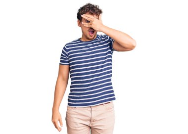 Kıvırcık saçlı, sıradan kıyafetler giyen, yüzü ve gözleri kapalı, utangaç ifadesiyle parmaklarından bakan genç yakışıklı bir adam.. 