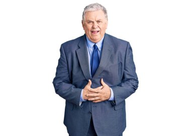 İş ceketi giyen yaşlı, kır saçlı adam gülümseyerek kahkahalarla gülüyor çünkü elleri vücutta olan komik bir şaka.. 