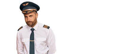 Sakallı, uçak pilotu üniforması giyen, kuşkucu ve gergin, sorun yüzünden suratını asan yakışıklı bir adam. negatif kişi. 
