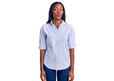 Genç Afro-Amerikalı kadın günlük kıyafetler giyip dudaklarıyla balık suratı yapıyor. Çılgınca ve komik bir jest. Komik ifade. 