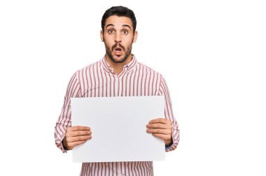 Genç İspanyol adam boş pankart tutuyor. Korkmuş ve ağzı açık kalmış, şaşırmış ve şaşırmış. 