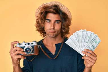 Elinde antika kamera ve dolar tutan genç İspanyol bir adam sıkıntılı ve endişeli, sinirli ve korkmuş. hüzünlü ifade. 