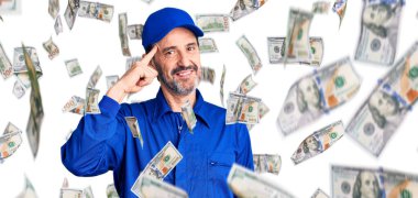 Orta yaşlı, yakışıklı, mekanik üniforma giyen, gülümseyen, tek parmakla kafasını gösteren, harika bir fikir ya da düşünce, iyi bir hafıza.